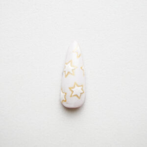 Tip de uña con un diseño de estrellas en tonos blancos y amarillos